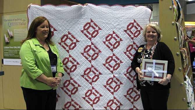 Quilt-story---Melisa-Morrison-right-stands-in-front-of-the-winning-quilt-design-Eye-Candy-and-accepts-the-award-from-Executive-Editor-of-Quilt-Sampler-magazine-Jennifer-Keltner
